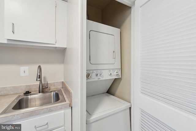 clothes washing area featuring stacked washer / dryer and sink