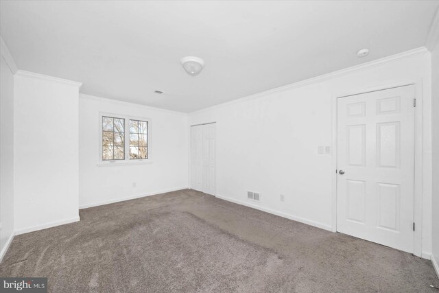 spare room featuring crown molding and carpet flooring