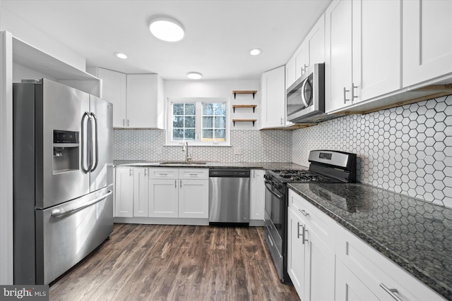 kitchen with sink, stainless steel appliances, dark hardwood / wood-style floors, white cabinets, and decorative backsplash