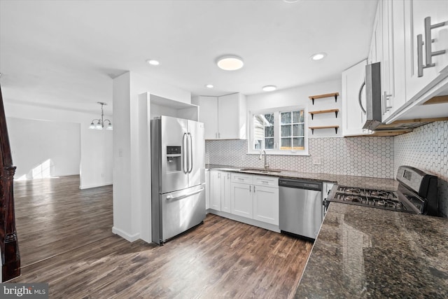 kitchen with dark hardwood / wood-style floors, sink, white cabinets, dark stone counters, and stainless steel appliances