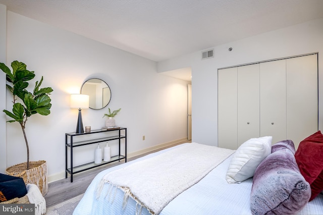 bedroom with a closet and light hardwood / wood-style flooring