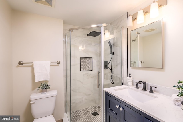 bathroom featuring vanity, an enclosed shower, and toilet