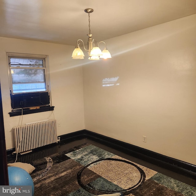 dining room with radiator heating unit and a chandelier