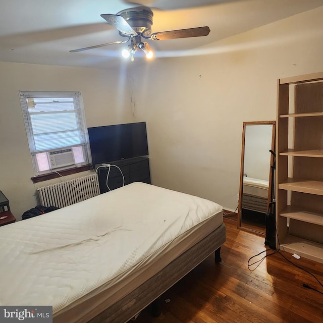 bedroom featuring dark hardwood / wood-style flooring, cooling unit, and ceiling fan