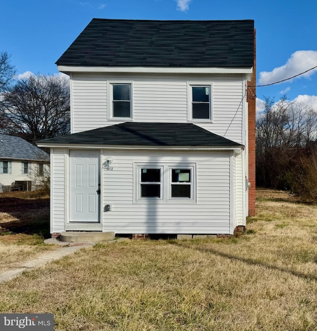 rear view of house featuring a yard