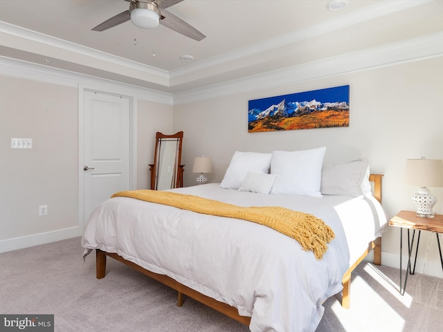 bedroom featuring crown molding, a raised ceiling, ceiling fan, and carpet flooring