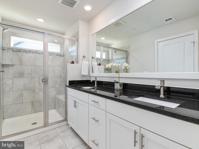 bathroom featuring vanity, tile patterned floors, and walk in shower