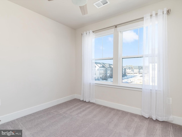 carpeted spare room featuring ceiling fan