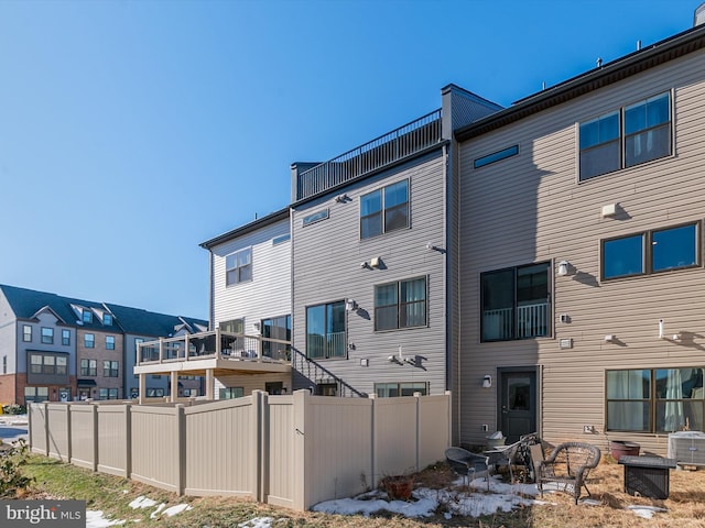 rear view of property with central AC