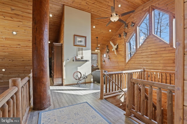 corridor with light hardwood / wood-style floors, high vaulted ceiling, and wooden ceiling