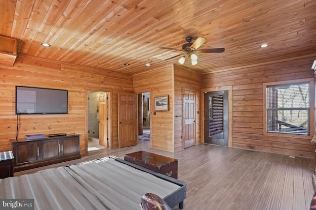 playroom featuring wood ceiling, light hardwood / wood-style floors, ceiling fan, and wood walls