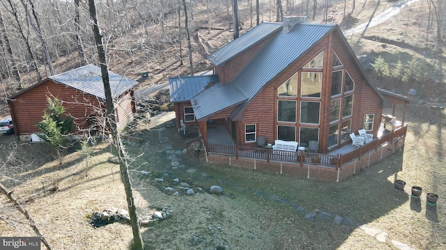 back of property featuring a wooden deck and a lawn