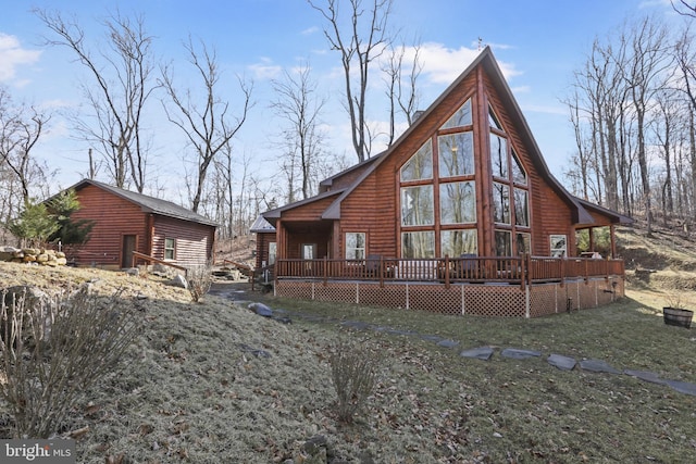 back of property with a wooden deck and a yard