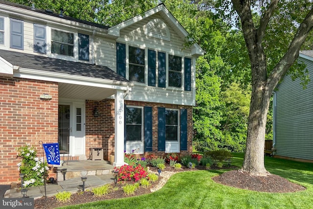 view of front of home featuring covered porch and a front lawn