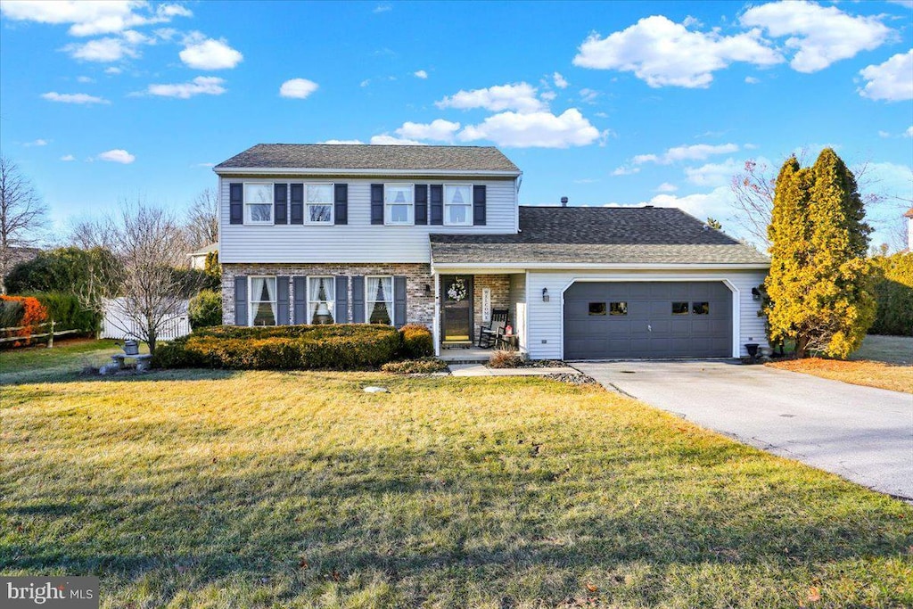 view of front property featuring a garage and a front lawn