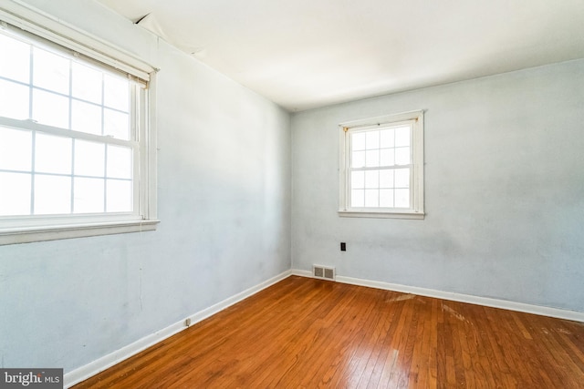 unfurnished room with hardwood / wood-style flooring