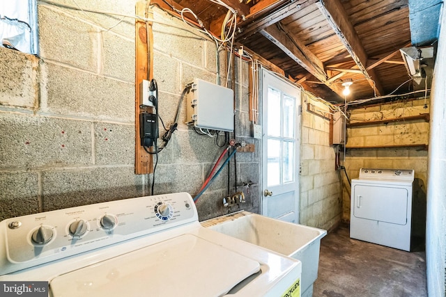 laundry area with separate washer and dryer and sink