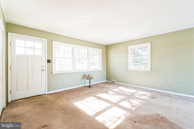 entrance foyer with a wealth of natural light and light colored carpet