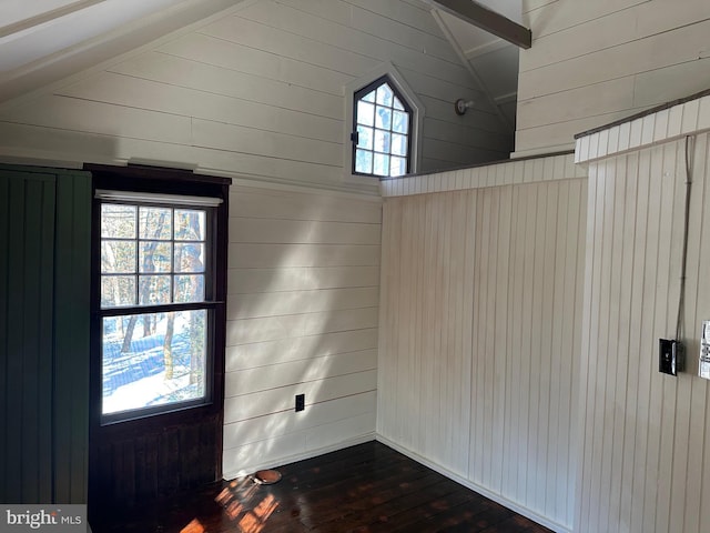 foyer with dark hardwood / wood-style floors, wooden walls, and lofted ceiling with beams