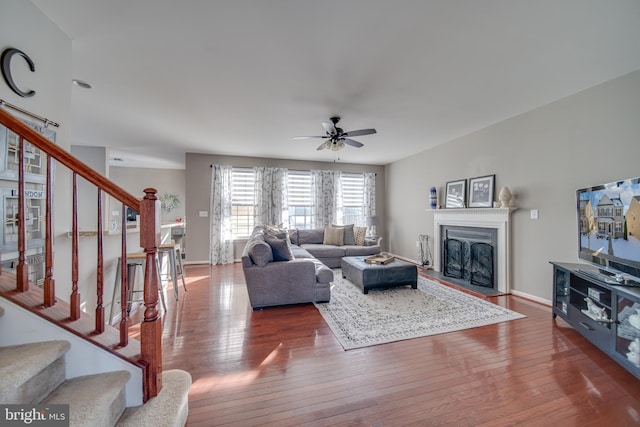 living room featuring ceiling fan and dark hardwood / wood-style floors