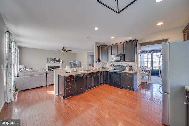 kitchen with ceiling fan with notable chandelier, tasteful backsplash, light hardwood / wood-style floors, black appliances, and dark brown cabinets