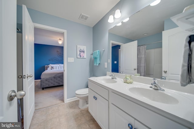 bathroom featuring tile patterned floors, vanity, toilet, and curtained shower