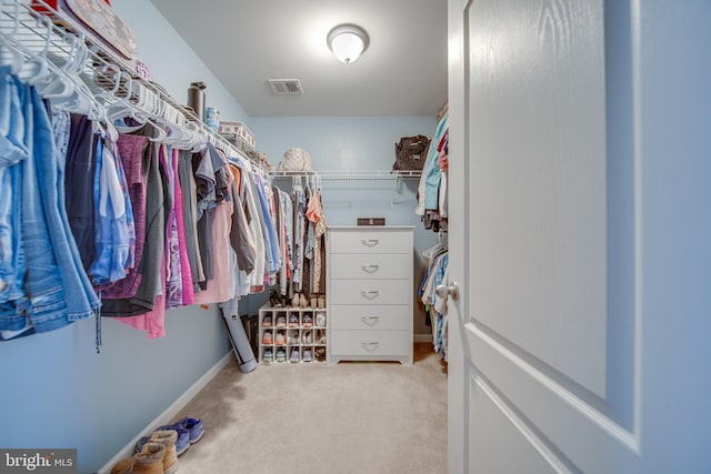 walk in closet with light colored carpet