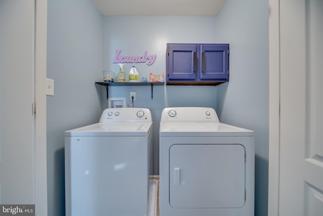 washroom featuring cabinets and washer and dryer