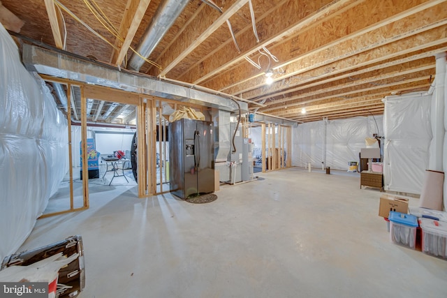 basement featuring black fridge and heating unit