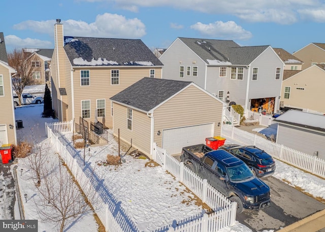 snow covered property with a garage