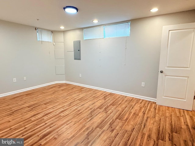 basement with electric panel and light wood-type flooring