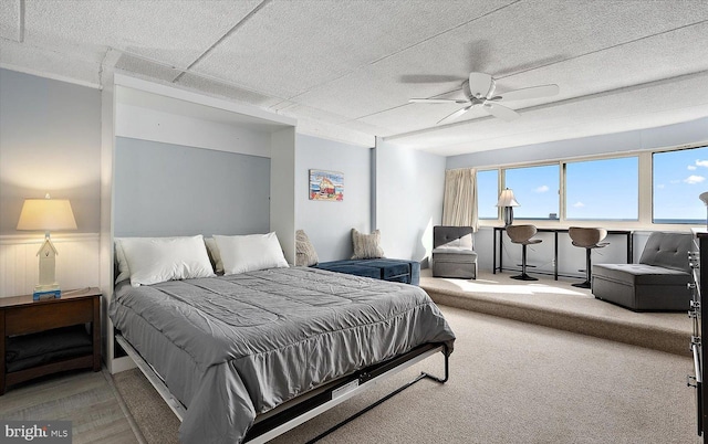 carpeted bedroom with a textured ceiling and ceiling fan