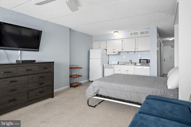 carpeted bedroom with ceiling fan, sink, and white fridge