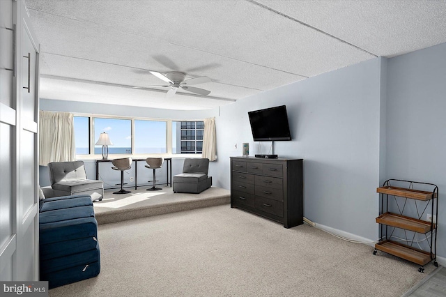 sitting room with carpet floors, a textured ceiling, and ceiling fan