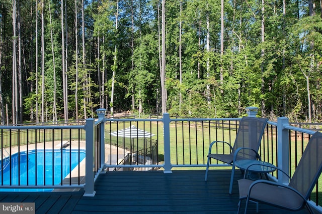 wooden deck featuring a fenced in pool and a yard