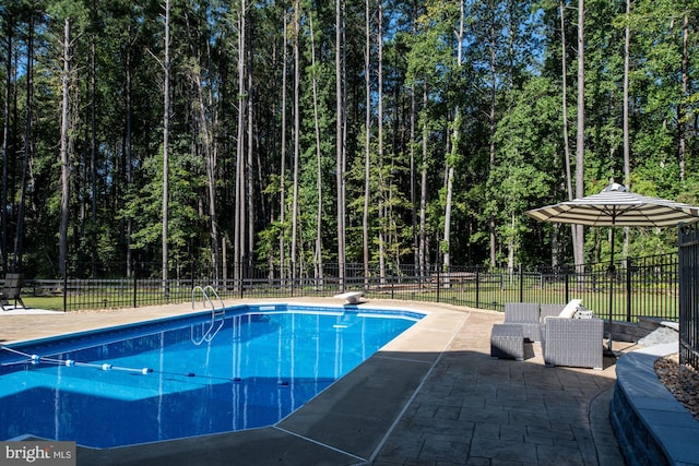 view of pool featuring a diving board and a patio