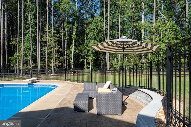 view of pool with a patio and a diving board