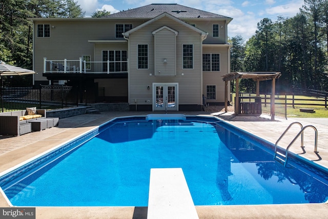 view of swimming pool featuring a patio, a pergola, a diving board, and french doors