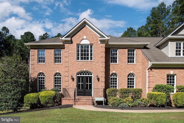 colonial home featuring a front lawn