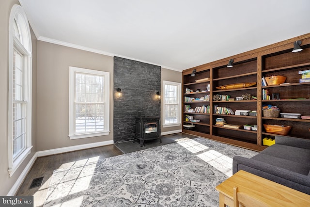 living area featuring dark wood-type flooring, ornamental molding, and a wood stove