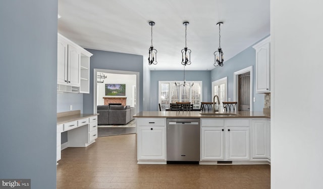 kitchen featuring sink, white cabinets, decorative light fixtures, stainless steel dishwasher, and kitchen peninsula