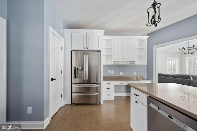 kitchen featuring appliances with stainless steel finishes, dark hardwood / wood-style floors, pendant lighting, and white cabinets