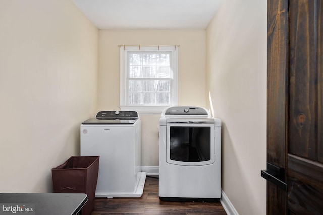 clothes washing area with separate washer and dryer and dark wood-type flooring