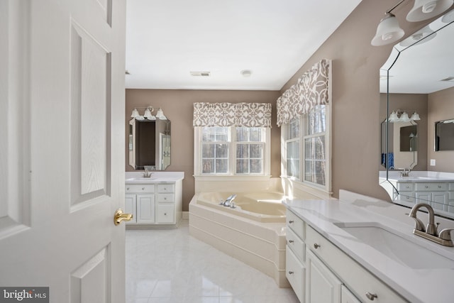 bathroom featuring vanity, tiled tub, and tile patterned flooring