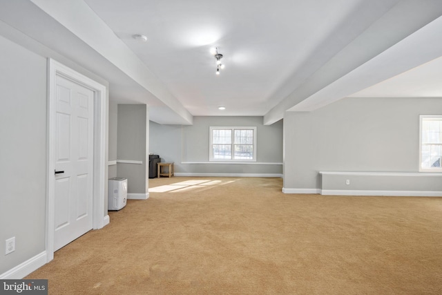 unfurnished living room with light colored carpet and a wood stove