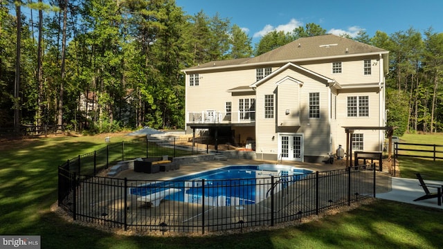 back of house featuring french doors, outdoor lounge area, a patio area, and a lawn