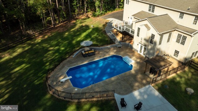 view of swimming pool with a patio, a lawn, a diving board, and french doors