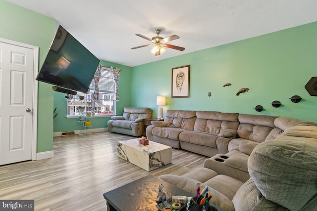 living area with ceiling fan, wood finished floors, and baseboards