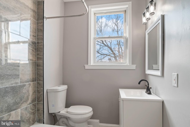 bathroom with vanity, toilet, and tiled shower