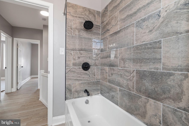 bathroom featuring hardwood / wood-style flooring and tiled shower / bath combo